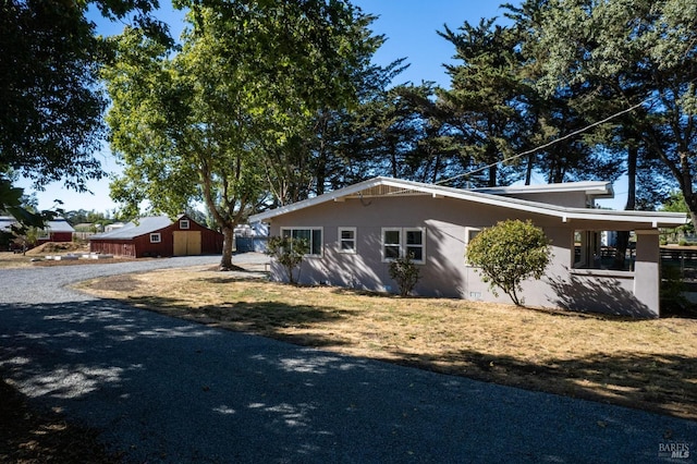 view of home's exterior with gravel driveway and stucco siding