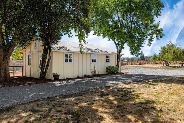 exterior space with an outbuilding, fence, and board and batten siding