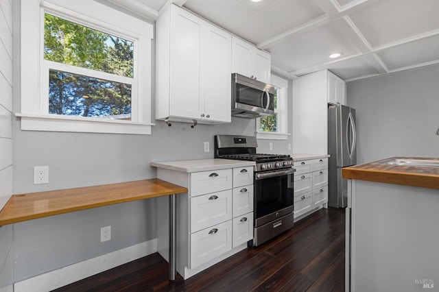 kitchen featuring dark wood-type flooring, white cabinets, a sink, and stainless steel appliances