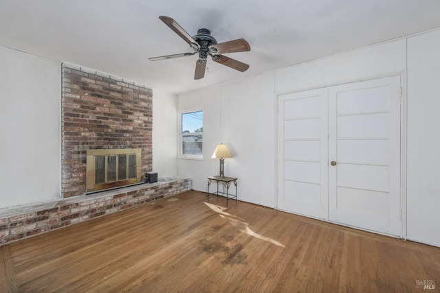 unfurnished living room with hardwood / wood-style floors, a fireplace, and ceiling fan