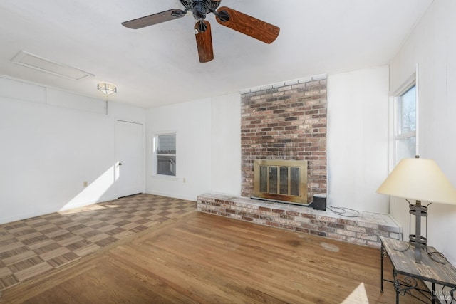 unfurnished living room with wood-type flooring, ceiling fan, and a fireplace