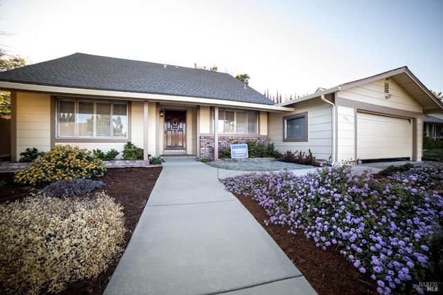 single story home featuring a porch and a garage