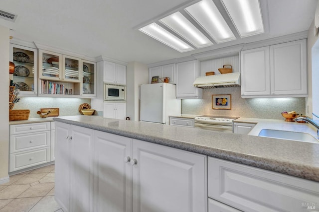 kitchen featuring white appliances, white cabinetry, sink, and premium range hood