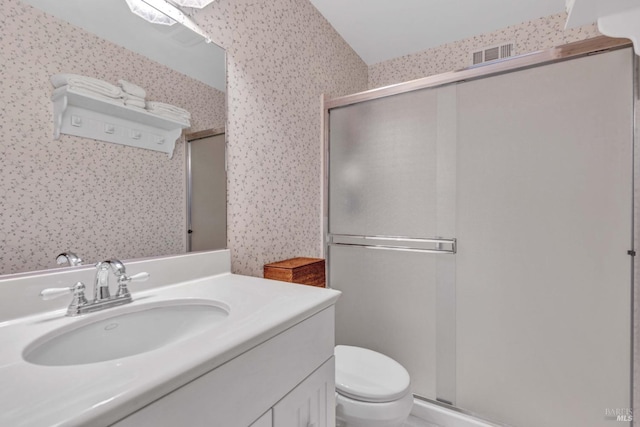 bathroom with toilet, a shower with shower door, and vanity