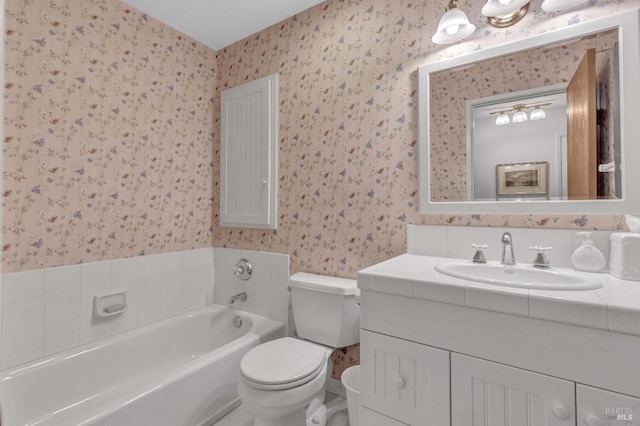 bathroom featuring vanity, toilet, and a tub