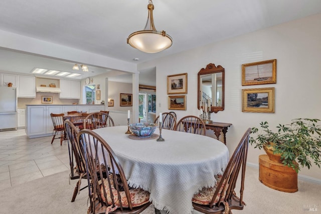 dining area featuring light carpet