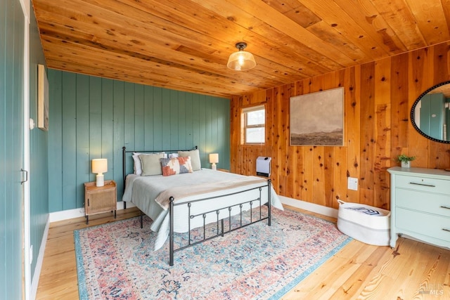 bedroom featuring wood ceiling, wooden walls, and light hardwood / wood-style floors