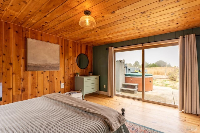 bedroom with wood ceiling, light hardwood / wood-style flooring, access to exterior, and wooden walls