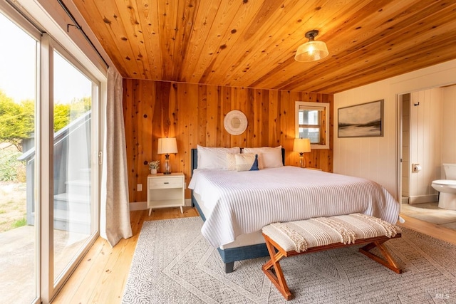 bedroom with wooden walls, ensuite bath, wooden ceiling, light hardwood / wood-style floors, and access to exterior