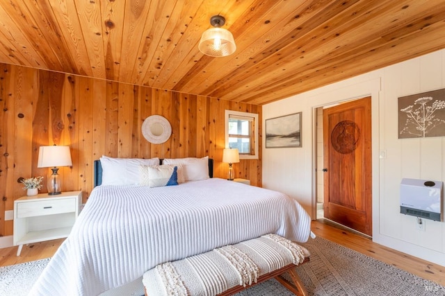 bedroom with wood walls, light hardwood / wood-style floors, and wooden ceiling