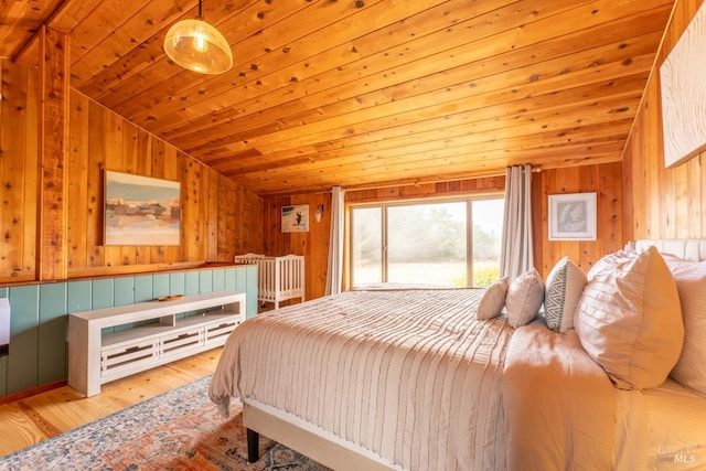 bedroom with light wood-type flooring, wood ceiling, lofted ceiling, and wood walls