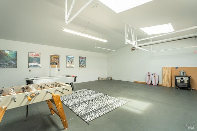 game room featuring a wood stove and concrete flooring