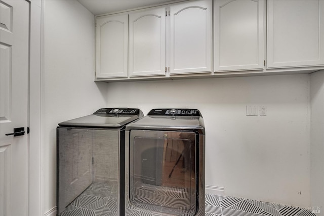 clothes washing area featuring cabinets and independent washer and dryer