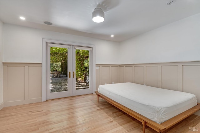 bedroom featuring french doors, light hardwood / wood-style flooring, and access to outside