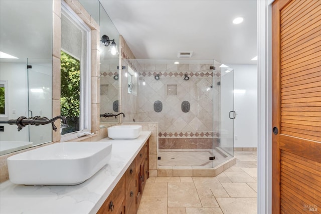 bathroom featuring vanity, a shower with shower door, and a wealth of natural light