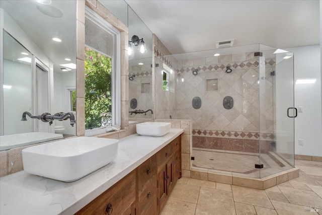 bathroom with plenty of natural light, walk in shower, and vanity