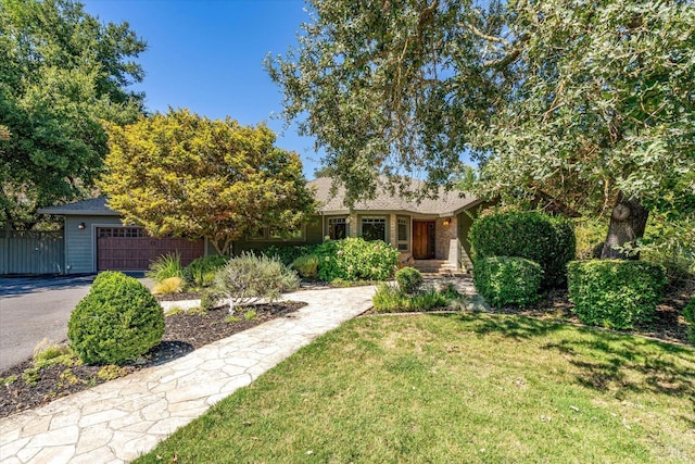 single story home featuring a garage and a front lawn