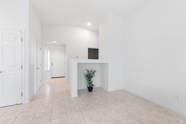 hall with arched walkways, light tile patterned flooring, recessed lighting, baseboards, and vaulted ceiling