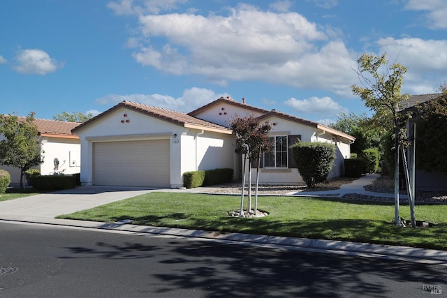 mediterranean / spanish home featuring stucco siding, an attached garage, a front yard, driveway, and a tiled roof