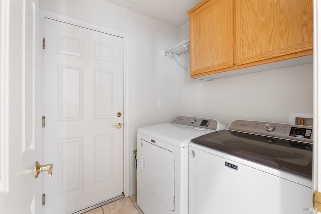 laundry room with cabinet space, light tile patterned floors, and separate washer and dryer