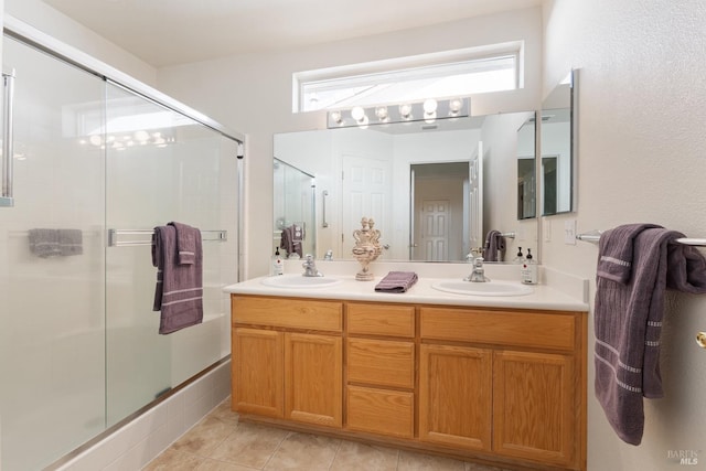 full bathroom featuring tile patterned floors, a shower with shower door, a sink, and double vanity