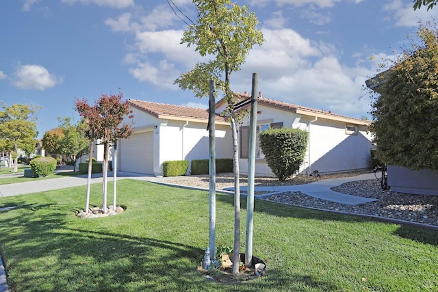 view of front of property with a front lawn, a tiled roof, stucco siding, a garage, and driveway