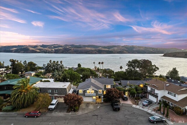 aerial view at dusk featuring a water view