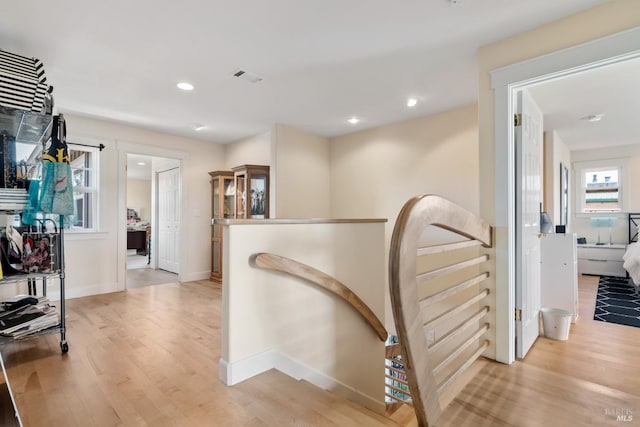 hallway featuring light wood-type flooring and plenty of natural light