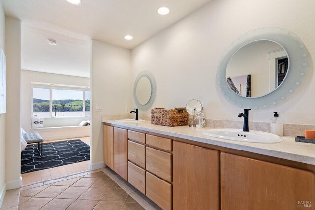 bathroom featuring tile patterned flooring, vanity, and a tile shower