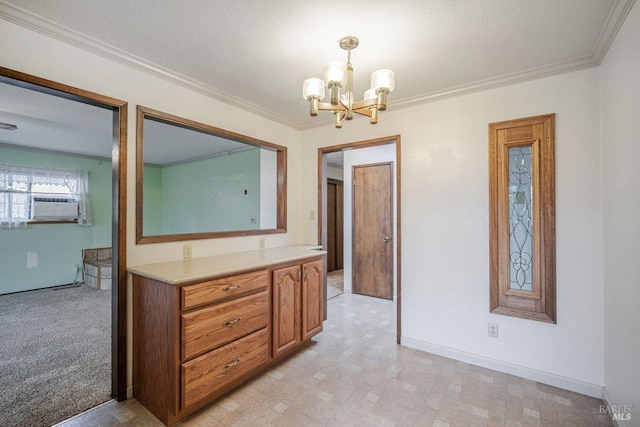 interior space with cooling unit, a textured ceiling, a chandelier, ornamental molding, and vanity