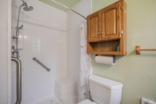 bathroom with a shower with shower curtain and toilet