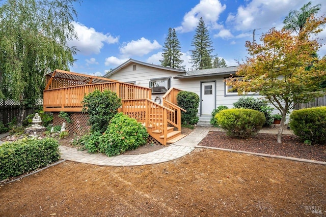 rear view of property featuring a wooden deck