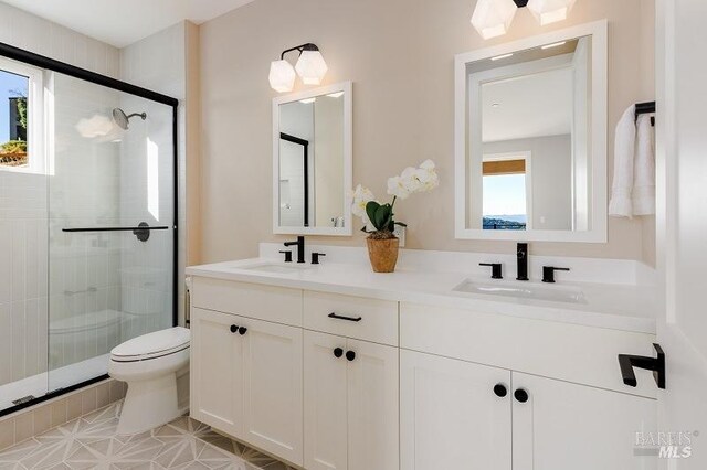 bathroom with tile patterned flooring, vanity, toilet, and an enclosed shower