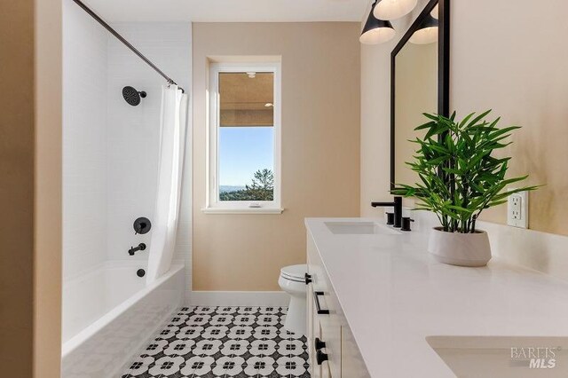 full bathroom with shower / bath combo with shower curtain, tile patterned floors, toilet, and vanity