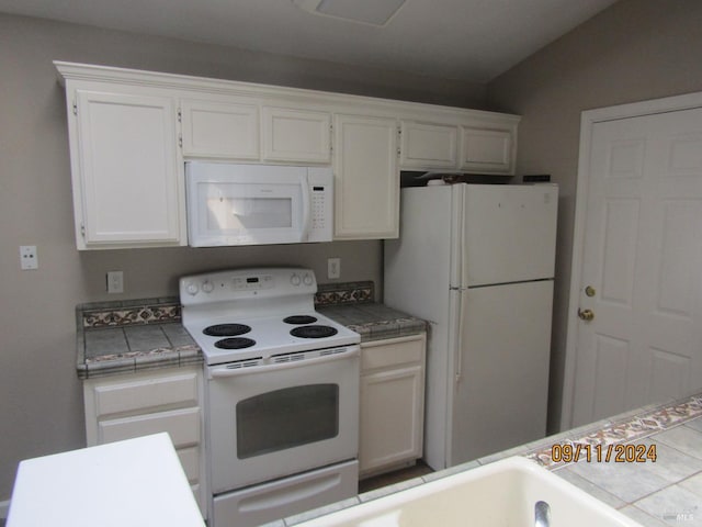 kitchen featuring tile counters, white cabinetry, and white appliances