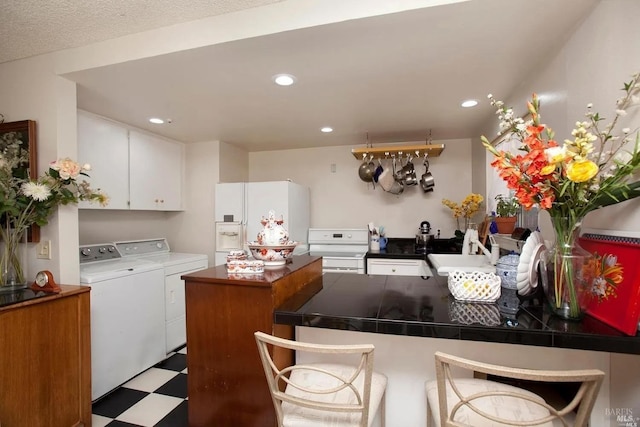 kitchen with separate washer and dryer, kitchen peninsula, white cabinets, and white appliances