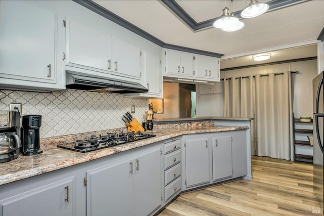 kitchen featuring black gas cooktop, backsplash, light stone countertops, crown molding, and light hardwood / wood-style floors