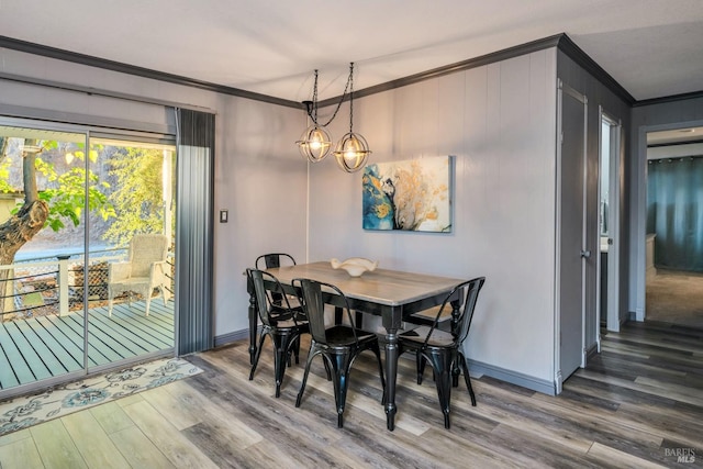 dining space with a notable chandelier, wood-type flooring, and crown molding