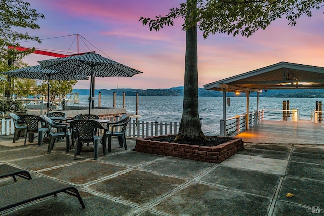 view of dock featuring a patio and a water view