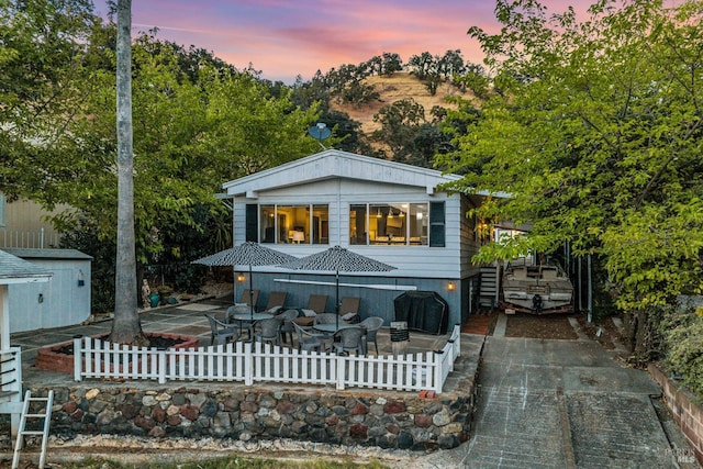 back house at dusk with a patio area