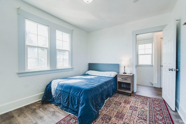 bedroom with wood-type flooring and multiple windows