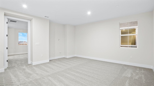 carpeted spare room featuring plenty of natural light