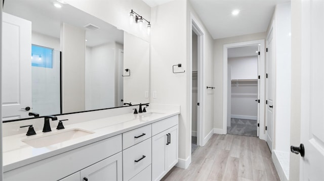 bathroom featuring a shower, hardwood / wood-style floors, and vanity