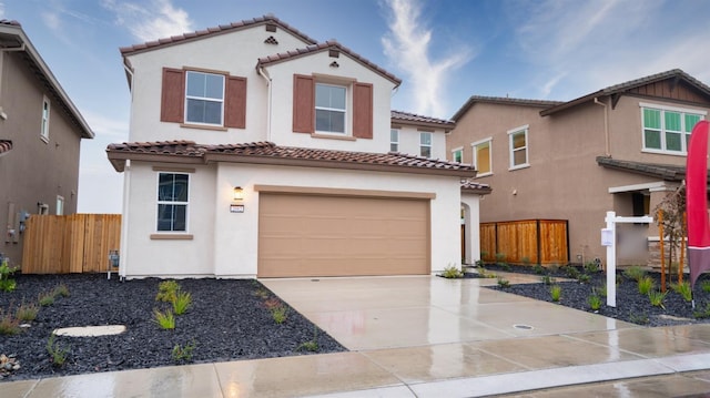 mediterranean / spanish-style house featuring stucco siding, driveway, and fence