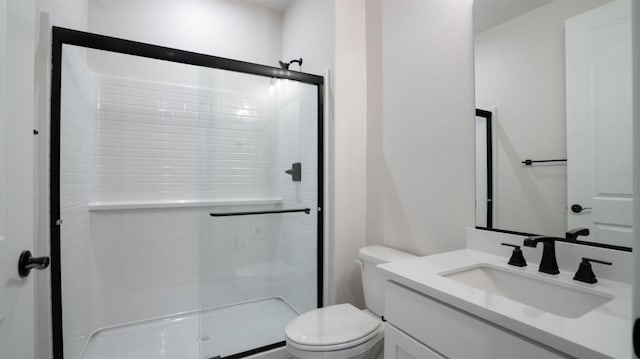 bathroom featuring an enclosed shower, vanity, and toilet