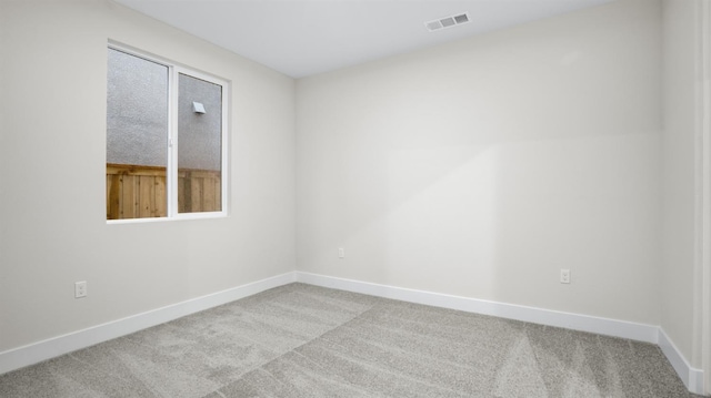 spare room featuring light carpet