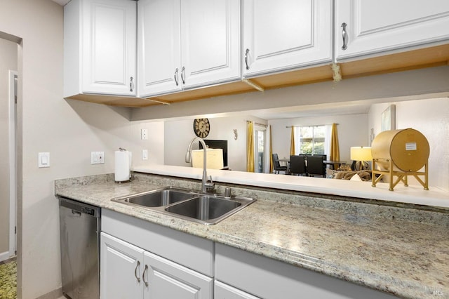 kitchen with stainless steel dishwasher, white cabinetry, and sink