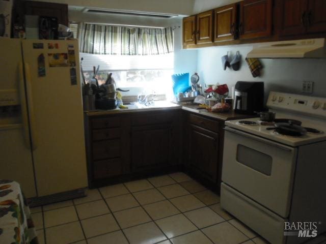 kitchen with white appliances, sink, and light tile patterned flooring