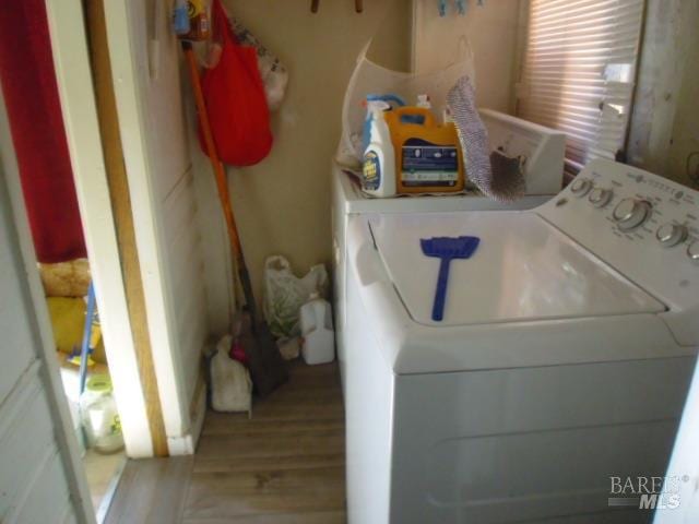 clothes washing area featuring hardwood / wood-style floors and washer and clothes dryer