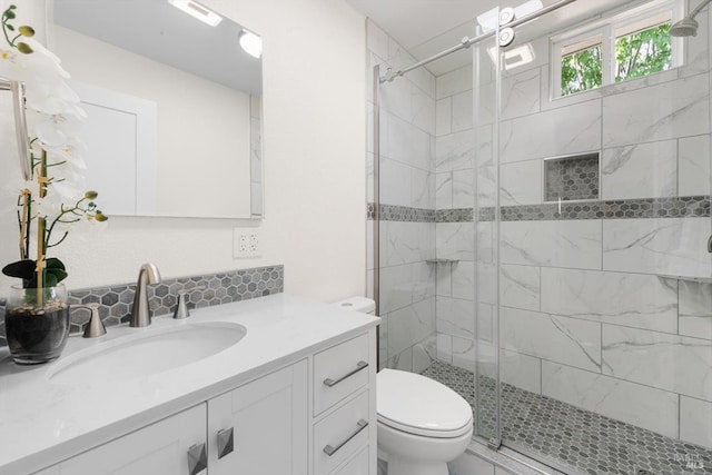 bathroom with walk in shower, vanity, and toilet